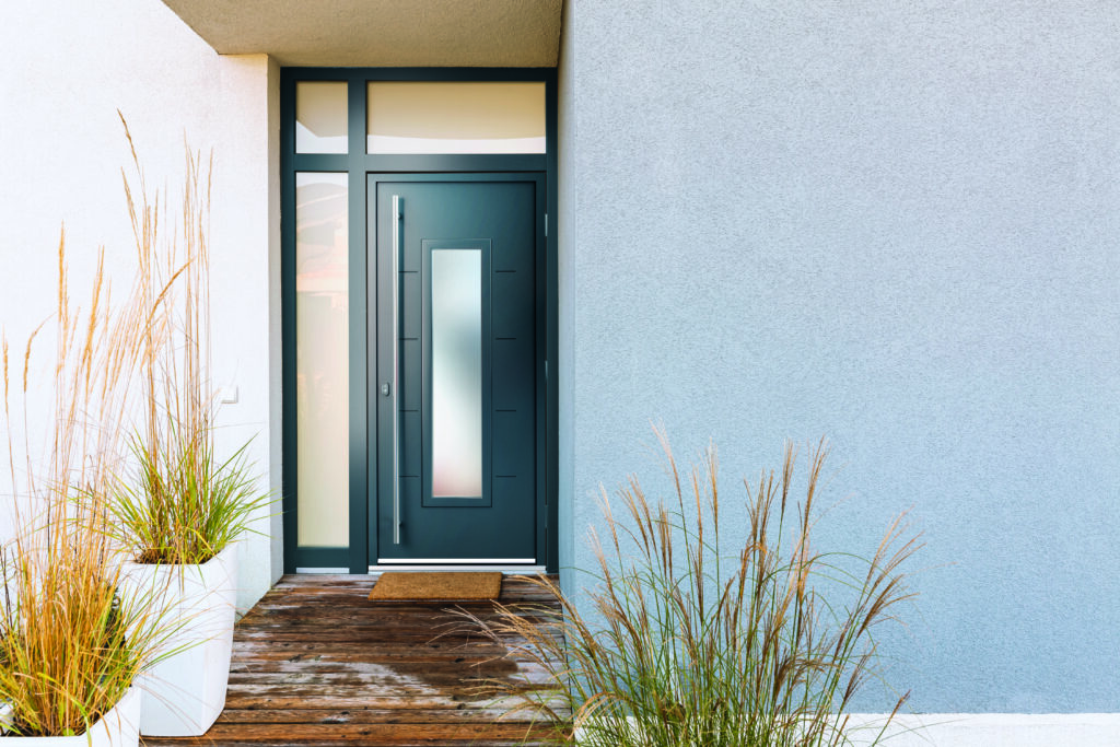 Grass in pot and wooden path in front of front door stylish subu | Aluminium Composite Doors This stylish aluminium composite door offers a warm welcome with zero fuss—proving that aluminium composite doors can look incredible and stay that way with minimal maintenance